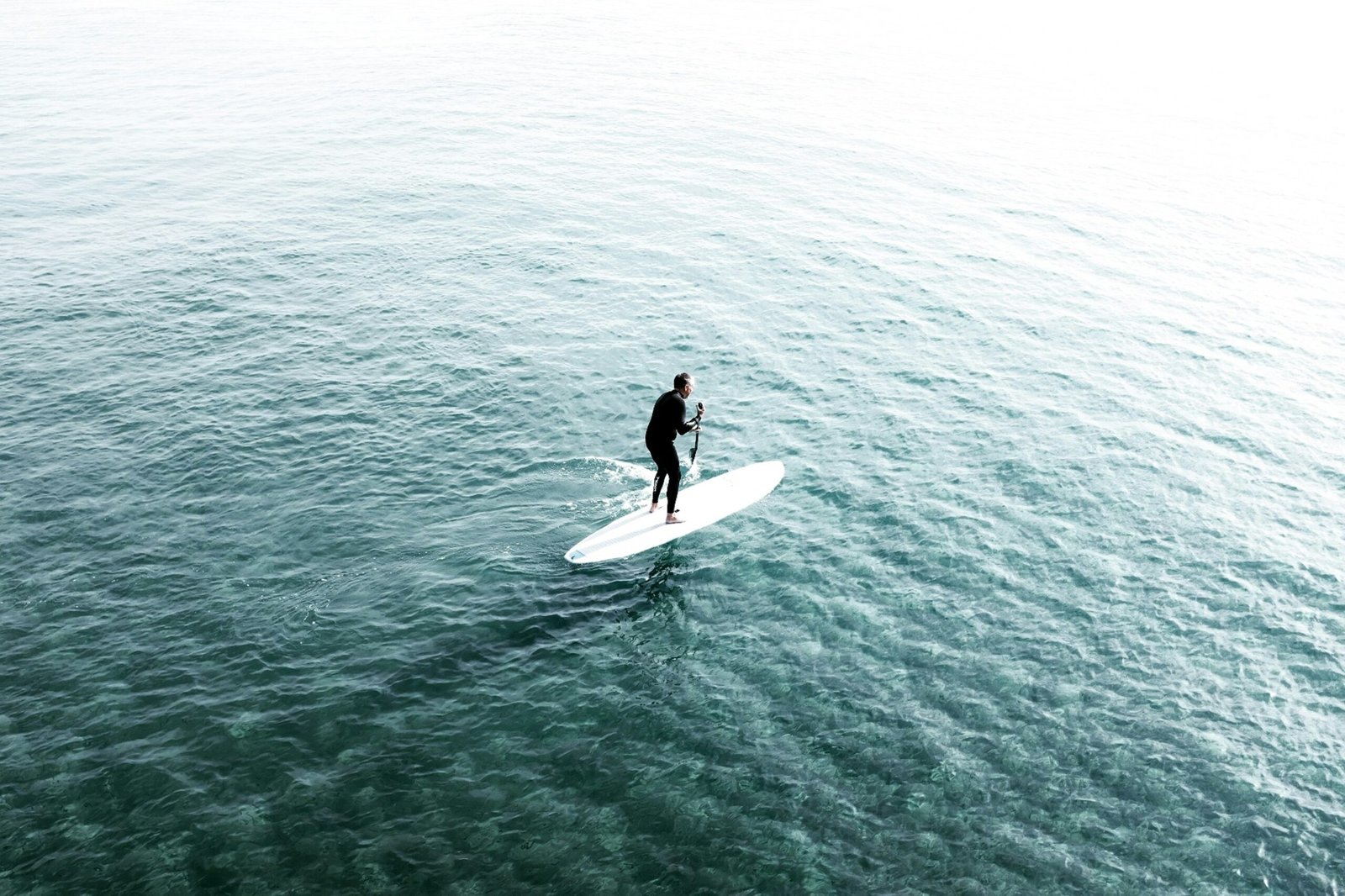 man riding surfboard on body of water